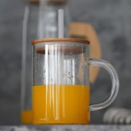 Tarro de vidrio con tapa de bambú y popote.