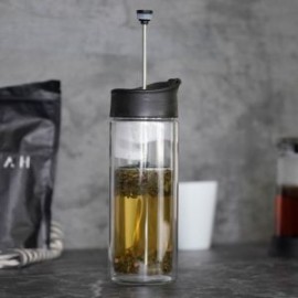 Termo con doble pared de vidrio, tapa de plástico enroscable, boquilla de seguridad a presión y filtro de plástico con rejilla.